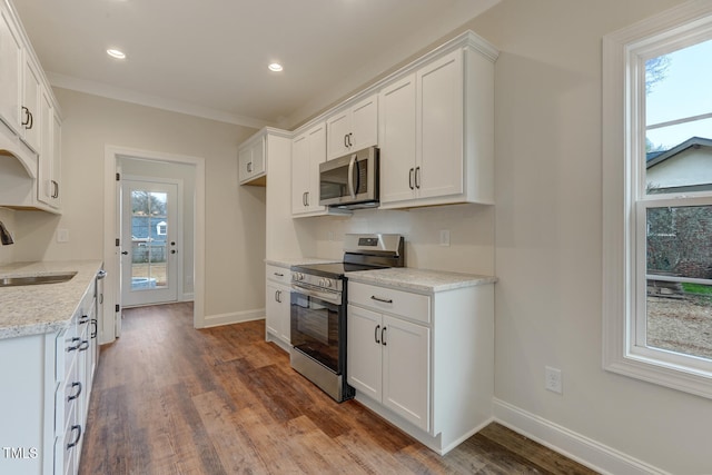 kitchen with white cabinetry, dark wood-style flooring, a sink, and stainless steel appliances