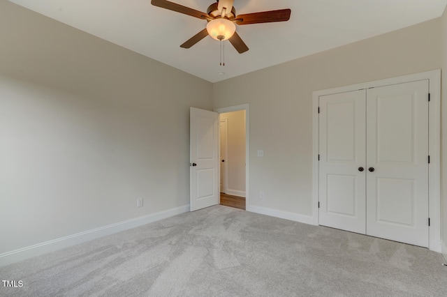 unfurnished bedroom featuring carpet flooring, a ceiling fan, a closet, and baseboards