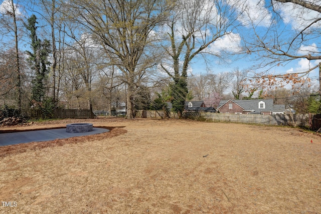 view of yard with a fire pit and fence