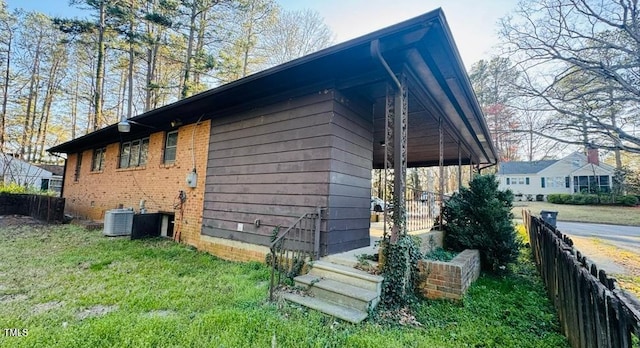 view of side of property featuring a lawn and fence