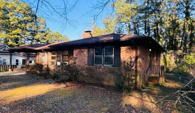 view of property exterior featuring brick siding and a chimney