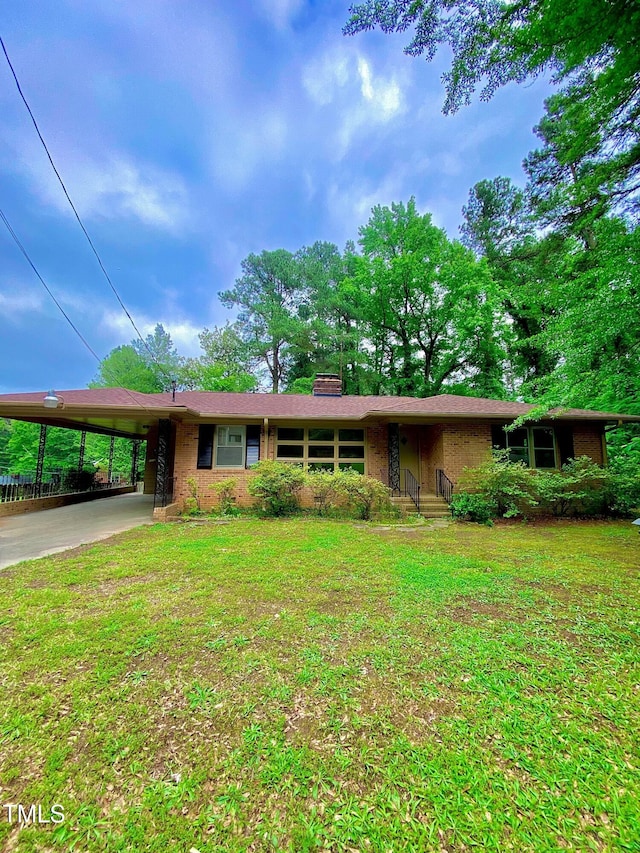 1115 Park Ave, Henderson, NC 27536 - ranch-style home featuring an attached carport, brick siding, a front yard, and a chimney