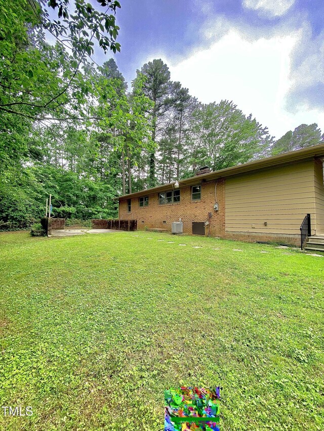 1115 Park Ave, Henderson, NC 27536 - view of green lawn with central AC and view of scattered trees