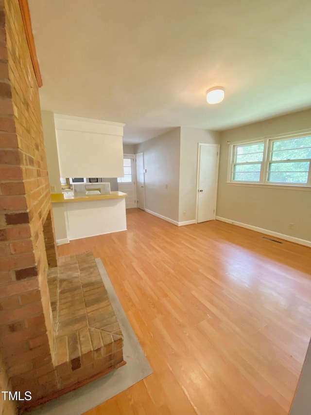 1115 Park Ave, Henderson, NC 27536 - unfurnished living room featuring baseboards and light wood-style flooring