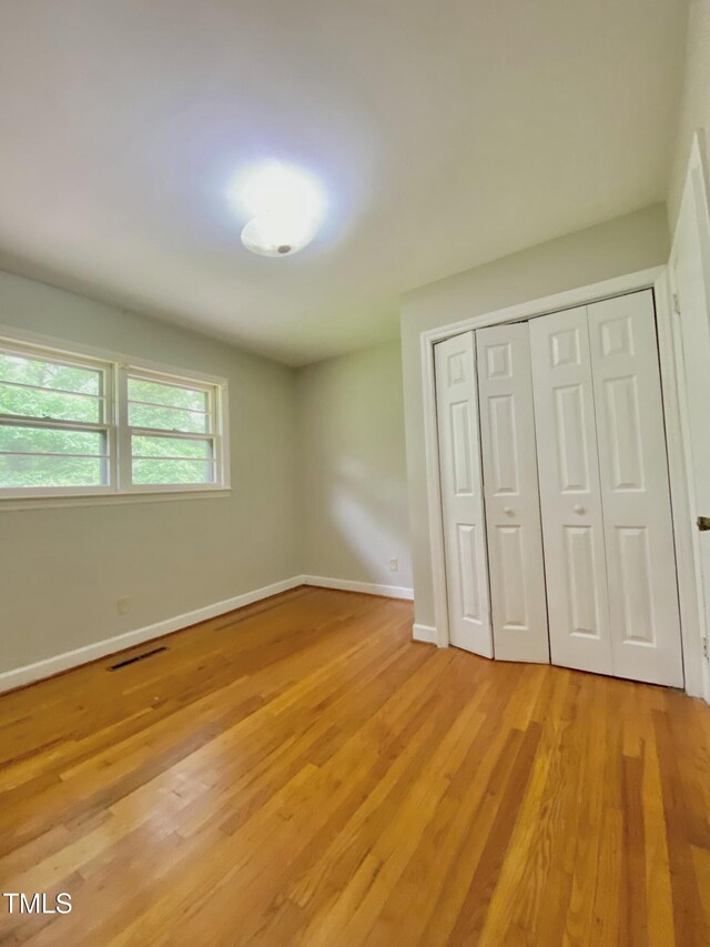 1115 Park Ave, Henderson, NC 27536 - unfurnished bedroom with light wood-style floors, baseboards, and a closet