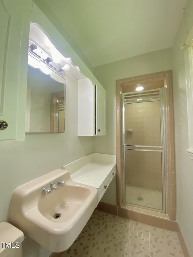 1115 Park Ave, Henderson, NC 27536 - full bathroom with a sink, a shower stall, toilet, and baseboards