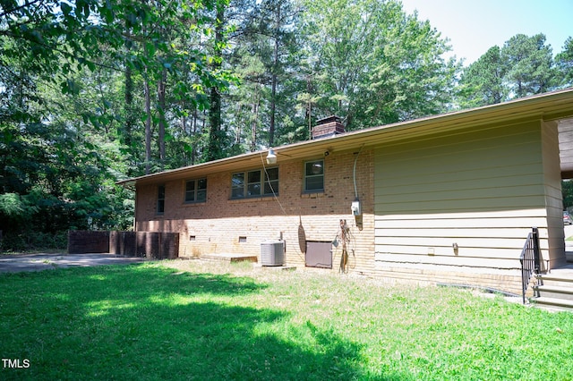 1115 Park Ave, Henderson, NC 27536 - view of side of property featuring brick siding, a lawn, and a chimney
