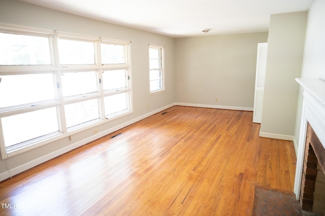 1115 Park Ave, Henderson, NC 27536 - unfurnished room featuring light wood-style flooring and a brick fireplace