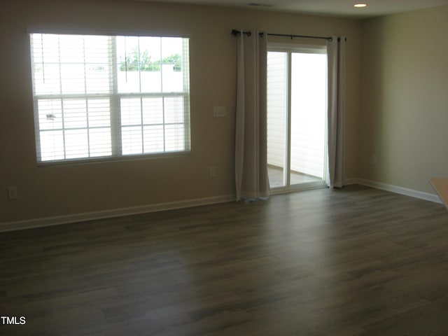 empty room with baseboards and dark wood-style flooring