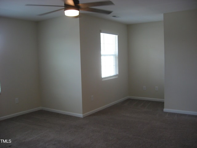 spare room featuring carpet, ceiling fan, and baseboards