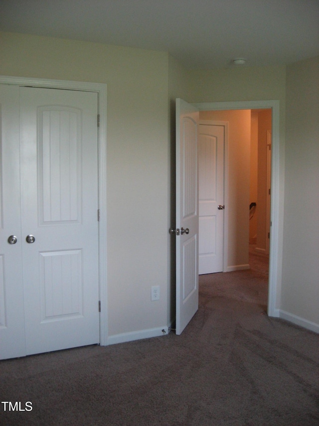 unfurnished bedroom with carpet, baseboards, and a closet