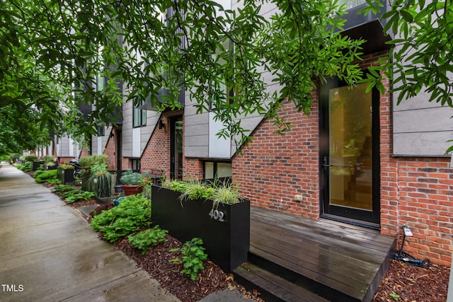 view of side of home with brick siding and a deck