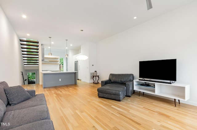 living area with light wood-style floors, recessed lighting, and baseboards