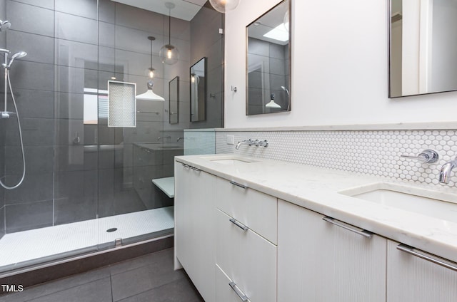 bathroom featuring a stall shower, double vanity, tile patterned flooring, tasteful backsplash, and tile walls