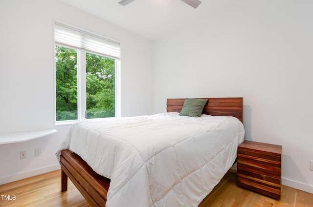 bedroom featuring light wood-type flooring, baseboards, and ceiling fan