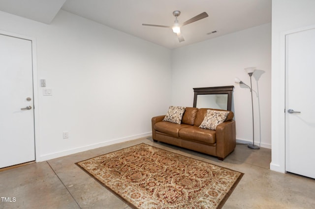 living area with finished concrete flooring, a ceiling fan, and baseboards
