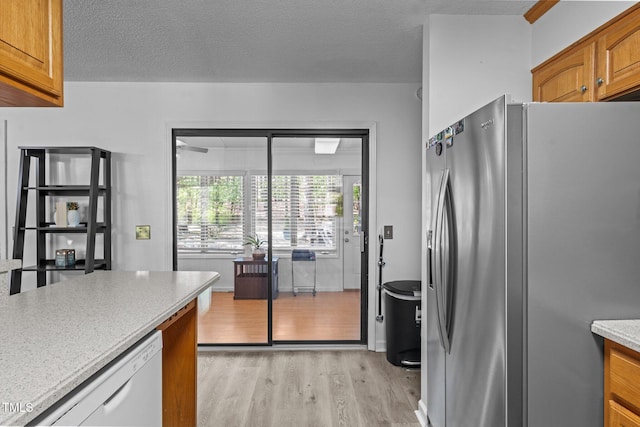 1801 Irish Blvd, Sanford, NC 27332 - kitchen with dishwasher, light wood-type flooring, stainless steel fridge, brown cabinetry, and a textured ceiling