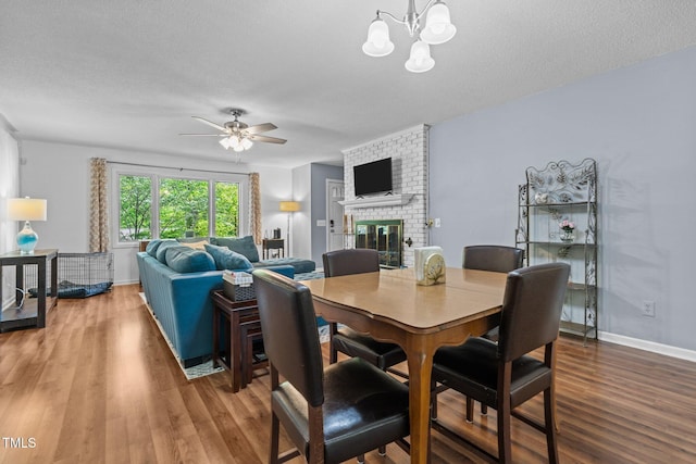 1801 Irish Blvd, Sanford, NC 27332 - dining room with a brick fireplace, wood finished floors, baseboards, a textured ceiling, and ceiling fan with notable chandelier