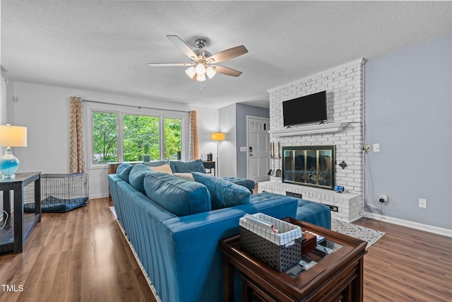 1801 Irish Blvd, Sanford, NC 27332 - living area with a textured ceiling, baseboards, a ceiling fan, wood finished floors, and a fireplace