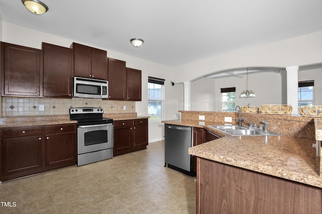 5824 Lady Way, Hope Mills, NC 28348 - kitchen featuring decorative columns, a sink, backsplash, appliances with stainless steel finishes, and arched walkways