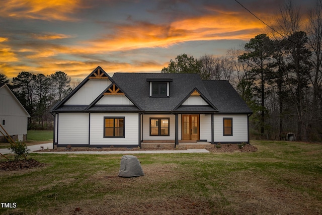 modern farmhouse with a lawn and roof with shingles