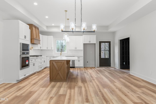 kitchen featuring white cabinetry, a raised ceiling, stainless steel appliances, and tasteful backsplash