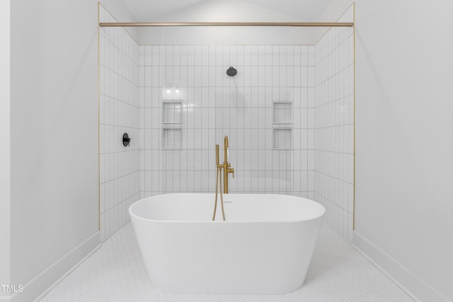 bathroom featuring a soaking tub, a sink, a tile shower, and tile walls