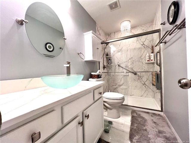 full bath with toilet, vanity, a marble finish shower, and visible vents