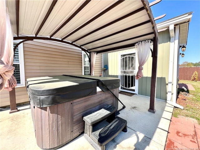 view of patio / terrace featuring fence and a hot tub