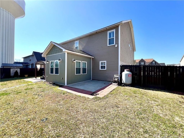 rear view of property featuring a patio area, fence, and a lawn