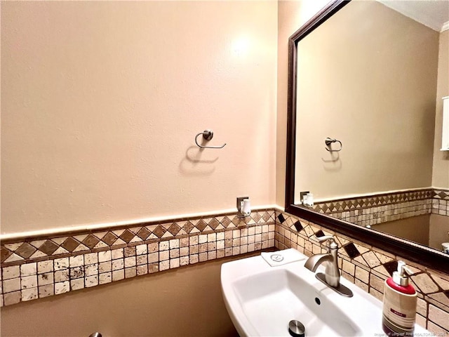 bathroom featuring tile walls, a sink, and a wainscoted wall
