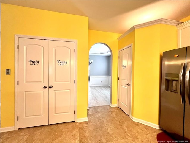interior space with baseboards and arched walkways