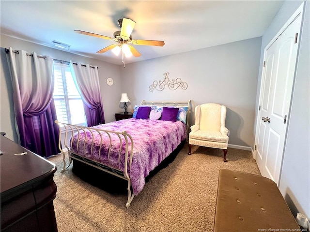 carpeted bedroom with baseboards, a ceiling fan, and visible vents