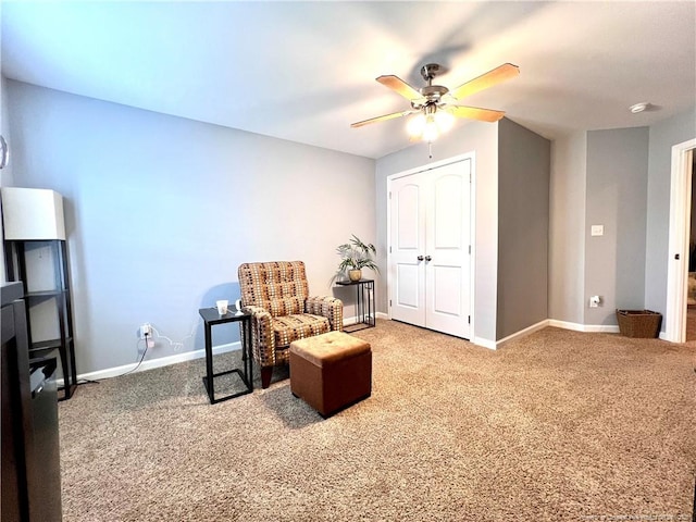 living area with ceiling fan, baseboards, and carpet floors