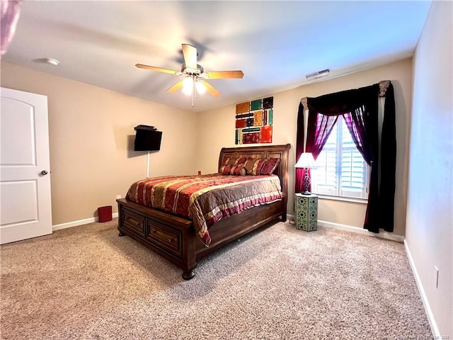 carpeted bedroom with visible vents, baseboards, and ceiling fan