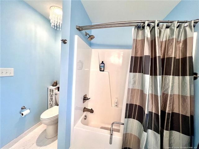 bathroom with toilet, shower / bath combo, and baseboards
