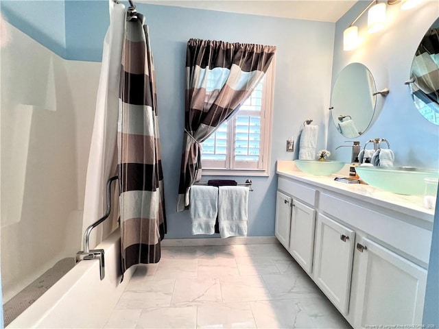full bath featuring shower / tub combo with curtain, vanity, and marble finish floor
