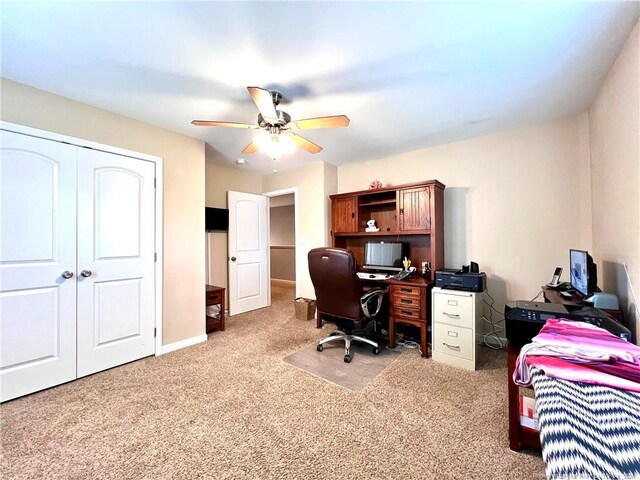 carpeted office with baseboards and a ceiling fan