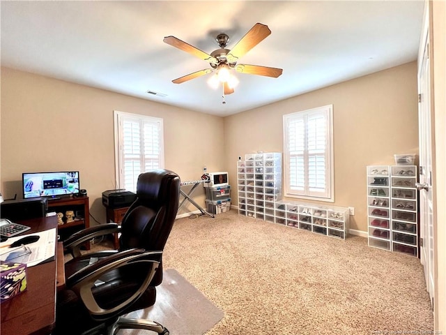 carpeted home office with visible vents, baseboards, and a ceiling fan