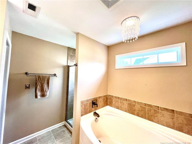 full bathroom with visible vents, a bath, a shower stall, and an inviting chandelier