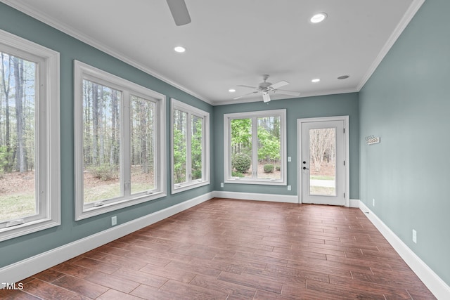 unfurnished sunroom featuring crown molding, wood finished floors, baseboards, and recessed lighting
