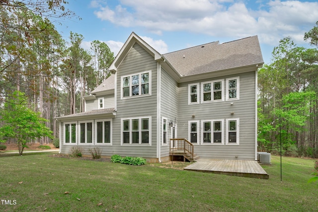 back of property with a yard, a shingled roof, a deck, and central AC