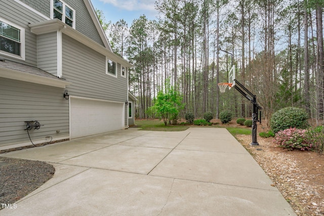 view of patio / terrace featuring an attached garage and concrete driveway