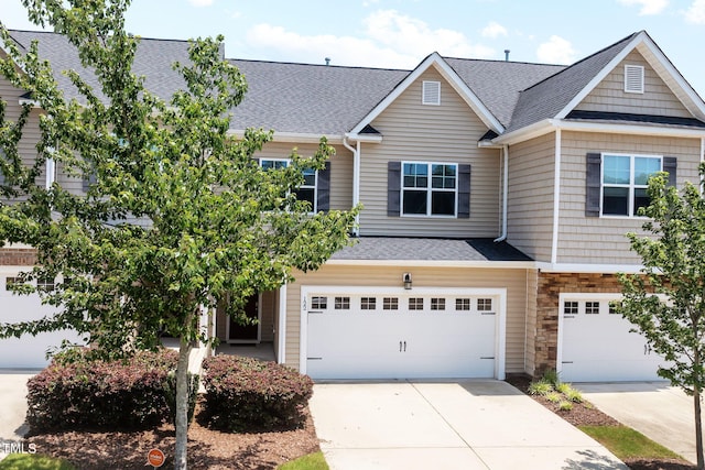 122 Torpoint Rd, Durham, NC 27703 - view of property featuring a garage, a shingled roof, driveway, and stone siding