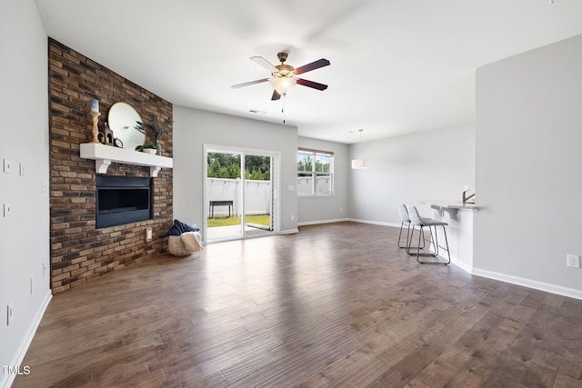 122 Torpoint Rd, Durham, NC 27703 - unfurnished living room with a ceiling fan, dark wood-style flooring, and a brick fireplace