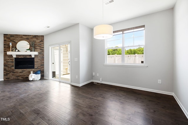 122 Torpoint Rd, Durham, NC 27703 - unfurnished living room with healthy amount of natural light, a brick fireplace, and dark wood-style floors