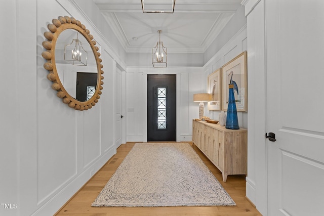 1208 Hunting Ridge Rd, Raleigh, NC 27615 - foyer entrance featuring a chandelier, crown molding, light wood finished floors, and a decorative wall