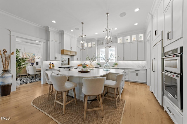 1208 Hunting Ridge Rd, Raleigh, NC 27615 - kitchen with double oven, light countertops, a chandelier, decorative backsplash, and white cabinets