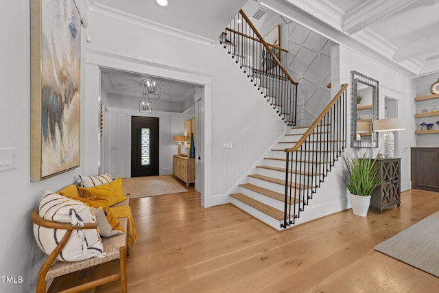1208 Hunting Ridge Rd, Raleigh, NC 27615 - entryway featuring ornamental molding, stairs, wood finished floors, a chandelier, and coffered ceiling