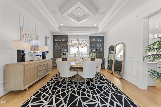 1208 Hunting Ridge Rd, Raleigh, NC 27615 - dining area featuring a decorative wall, light wood-type flooring, ornamental molding, a chandelier, and a raised ceiling